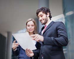 Male and female looking at paper document 