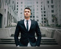 Male standing in front of block of offices 