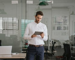 Young male professional looking on electronic tablet