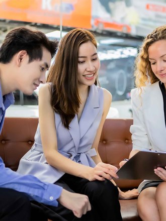 Woman guiding a man and woman through a process