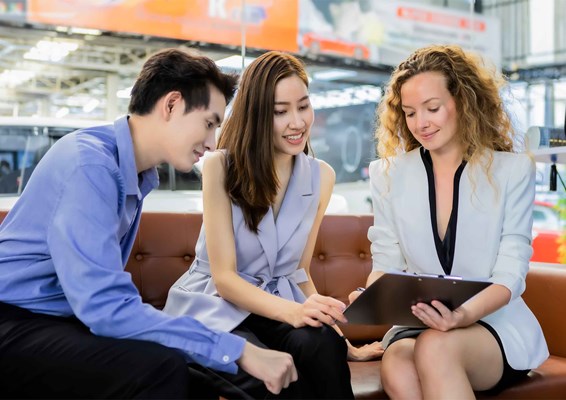 Woman guiding a man and woman through a process