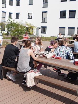 Students sitting outdoors on benches