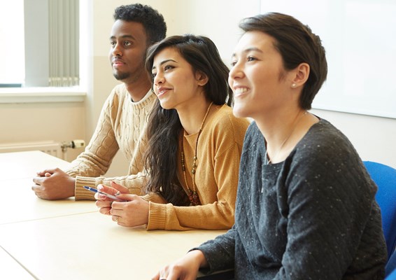 A group of smiling students smiling in a lecture