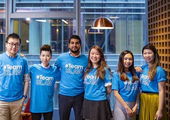 A group of ULaw students smiling and wearing #TeamULaw t-shirts