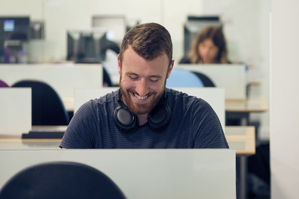 Smiling student studying in library space