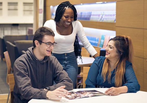 A group of students socialising and looking at Verdict Magazine