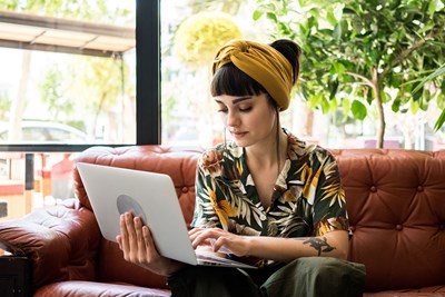 woman sat on a sofa on a laptop