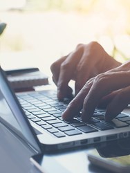 Close up of hands on a laptop keyboard