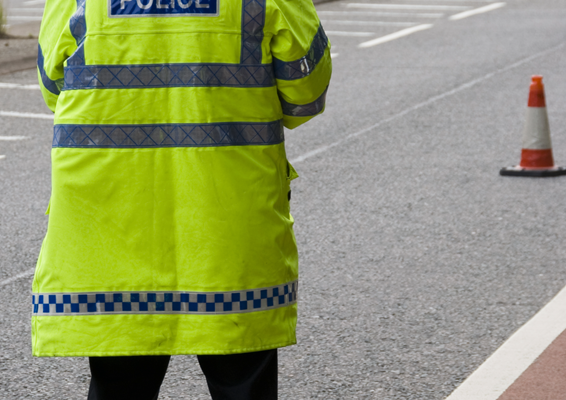 Male met police officer standing in the road for traffic monitoring